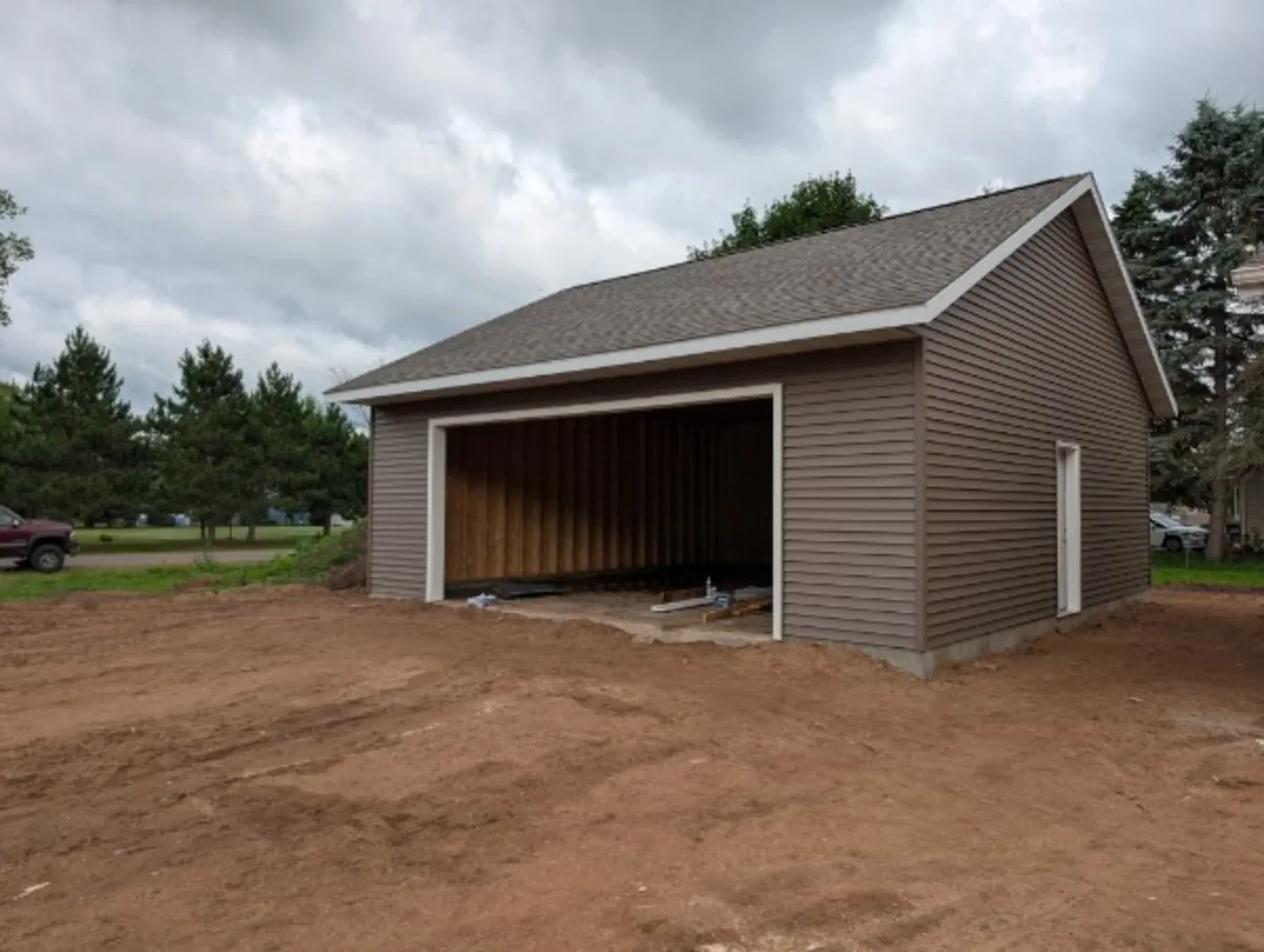 Completed 28x28 brown vinyl garage with shingle roof, Chippewa Valley WI