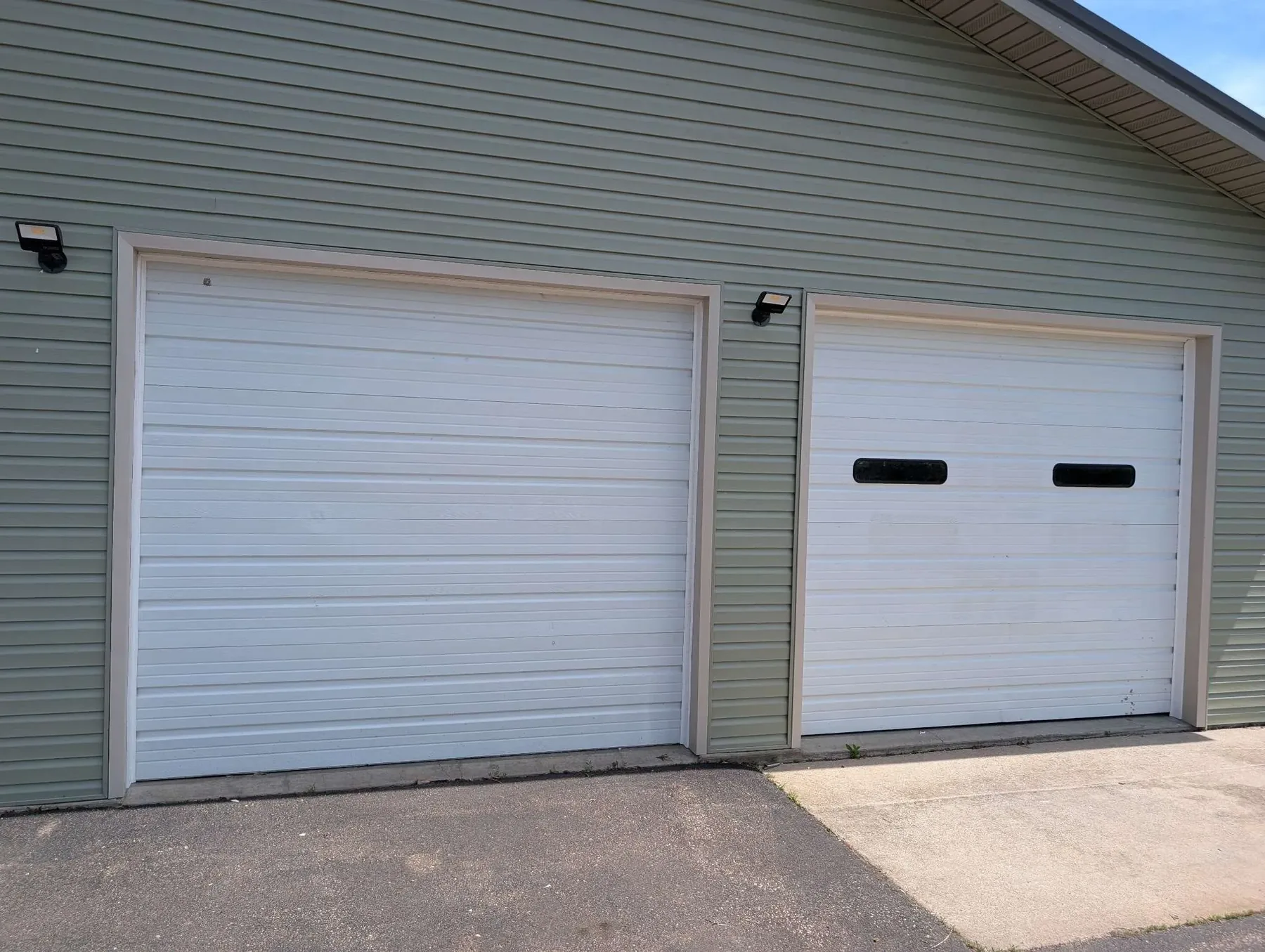 Double white roll-up garage doors with sage green lap siding, Carter Quality Construction